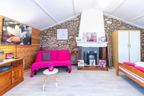 sala de estar con sofá rosa y chimenea en New - Gite Lylou piscine et spa, en Saint-Jean-de-Monts