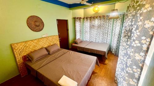 a bedroom with two beds and a window at Paris Guest House Airport in Bharatpur