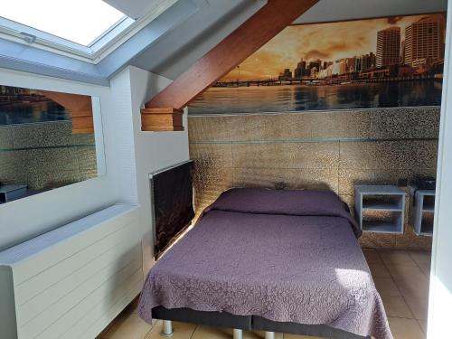 a bedroom with a bed with a painting on the wall at Le New Matinal in La Louvière
