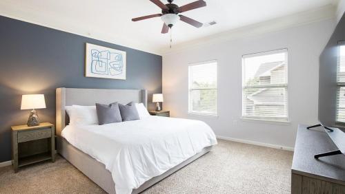 a bedroom with a white bed and a ceiling fan at Landing at The Sovereign at Overland Park Apartments - 1 Bedroom in St. Andrews Highlands in Overland Park