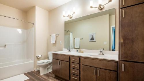 ein Badezimmer mit einem Waschbecken, einem WC und einem Spiegel in der Unterkunft Landing at Three Rivers - 1 Bedroom in Central Fort Wayne in Fort Wayne