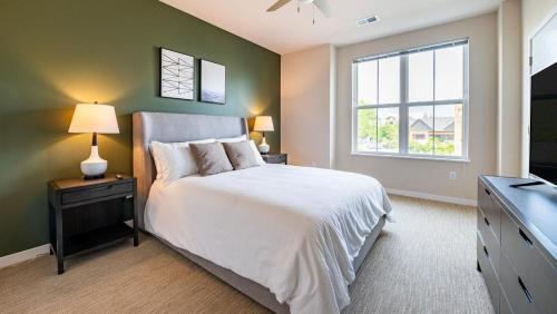a bedroom with a white bed and a window at Landing at Three Rivers - 1 Bedroom in Central Fort Wayne in Fort Wayne