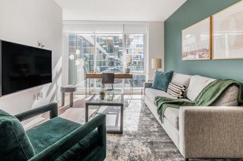 a living room with a couch and a tv at Landing at Logan Apartments - 2 Bedrooms in Logan Square in Chicago