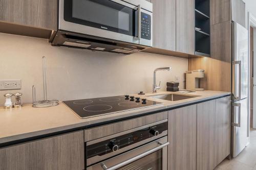 a kitchen with a stove and a microwave at Landing at Logan Apartments - 2 Bedrooms in Logan Square in Chicago