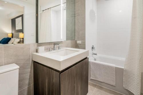 a bathroom with a sink and a toilet and a tub at Landing at Logan Apartments - 2 Bedrooms in Logan Square in Chicago
