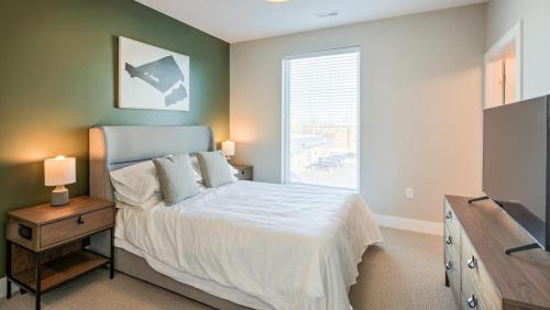 1 dormitorio con cama y ventana en Landing at Three Rivers - Studio in Central Fort Wayne, en Fort Wayne