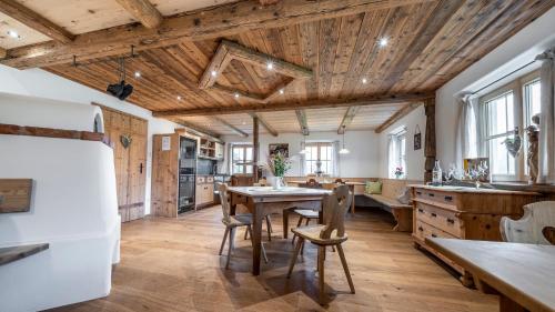 uma cozinha com tectos em madeira e uma mesa e cadeiras em Pension Lenz´n am Christlhof em Lenggries