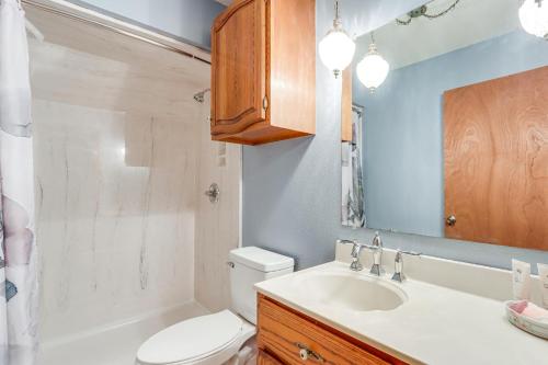 La salle de bains est pourvue de toilettes, d'un lavabo et d'un miroir. dans l'établissement Riverfront Baxter Springs Home with Deck and Grill!, à Baxter Springs