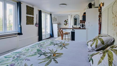 1 dormitorio con 1 cama con manta azul y blanca en Maisonnette cosy bord de Seine 30min paris, en Carrières-sous-Poissy