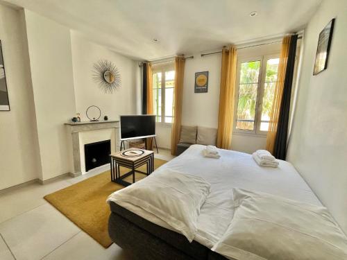 - une chambre avec un grand lit et une cheminée dans l'établissement Greyson apartment 3 from Palais by Welcome to Cannes, à Cannes