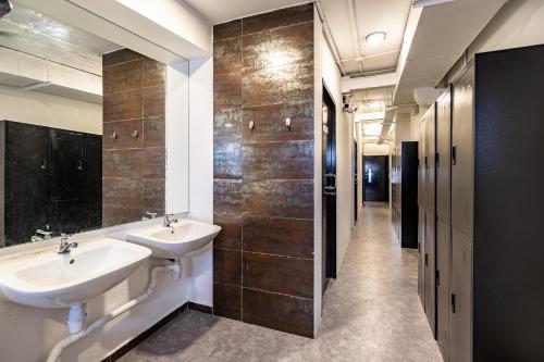a bathroom with two sinks and a walk in shower at Rucksack Inn Temple Street in Singapore
