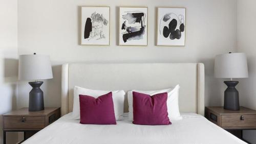 sypialnia z białym łóżkiem i różowymi poduszkami w obiekcie Landing at Mission Hill - 1 Bedroom in New Braunfels w mieście New Braunfels