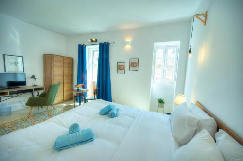 a bedroom with a large white bed with blue pillows at Cozy 1bedroom, roof terrace near Valletta DAZZ1-2 in Il-Furjana