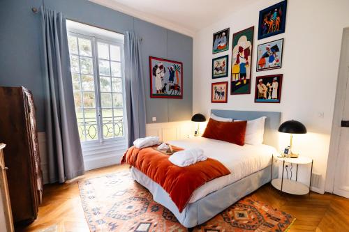 Pressagny l'OrgueilleuxにあるDomaine du Chesneyのベッドルーム1室(ベッド1台付)が備わります。壁には絵画が飾られています。