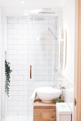 a white bathroom with a sink and a mirror at Pye Corner Cottage, by Solace Stays in Newport