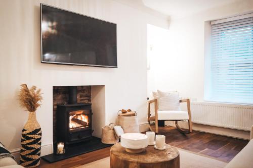 a living room with a fireplace and a flat screen tv at Pye Corner Cottage, by Solace Stays in Bellaghy