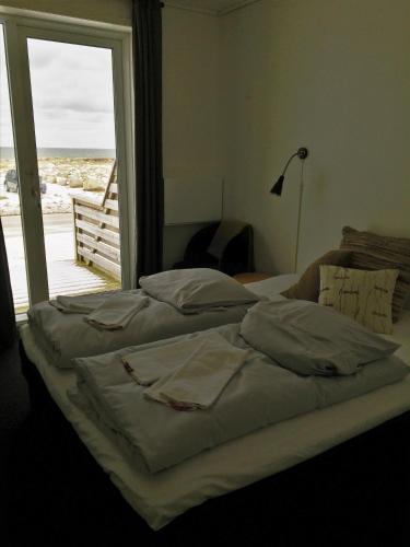 a bed in a bedroom with a view of the ocean at B&B by the Sea Hirtshals in Hirtshals