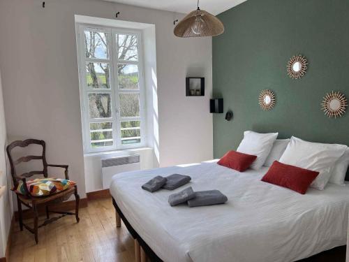 a bedroom with a large white bed with red pillows at Résidence thermale La Chaldette in Brion