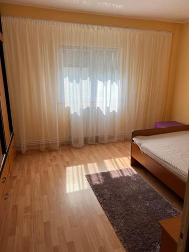 - une chambre avec un lit et une fenêtre avec un tapis dans l'établissement Apartament Faleza Nord, à Constanţa