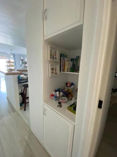 a kitchen with white cabinets and a sink in a room at Flat aconchegante à beira-mar in Vera Cruz de Itaparica