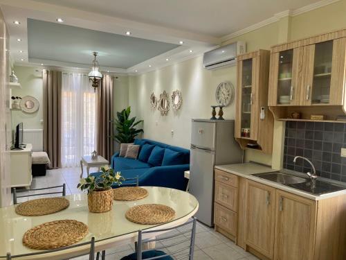 una cucina e un soggiorno con divano blu di Olivia - Christine's House ad Áfitos