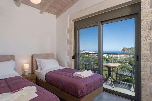 een slaapkamer met 2 bedden en uitzicht op de oceaan bij Sun Flower Villas in Agia Marina Nea Kydonias