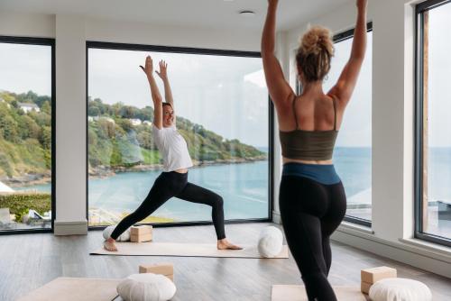 two women doing yoga in a room with a view at Carbis Bay and Spa Hotel in St Ives
