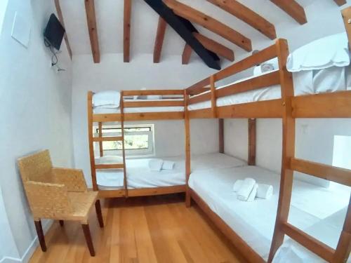 a room with two bunk beds and a chair at 6 bedrooms house with furnished garden and wifi at Otanes 4 km away from the beach in Otañes