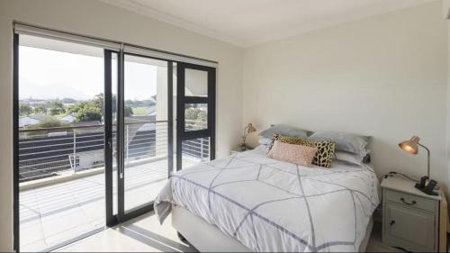 a bedroom with a bed and a large window at Immaculate 2-Bed Apartment in Cape Town in Cape Town