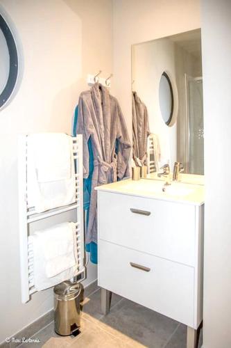 une salle de bain avec un lavabo blanc et un miroir dans l'établissement Studio confortable à Abondant, 30 m² avec jardin équipé, à Abondant