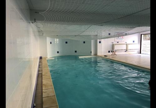 een zwembad met blauw water in een gebouw bij Appartement centre-ville d'Uzès in Uzès