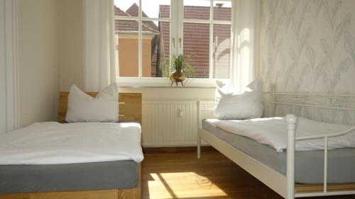 two beds in a room with a window at Ferienwohnungen Altstadt in Plau am See