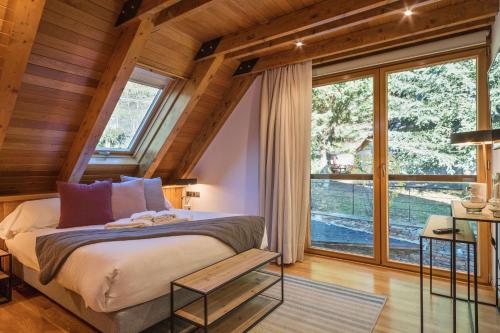 a bedroom with a bed and a large window at Luderna - Casa con jardín Montcorbison in Vielha