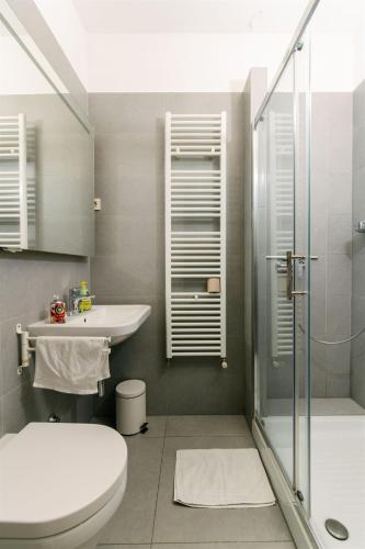 a bathroom with a toilet and a sink and a shower at Tia Apartments and Rooms in Zagreb