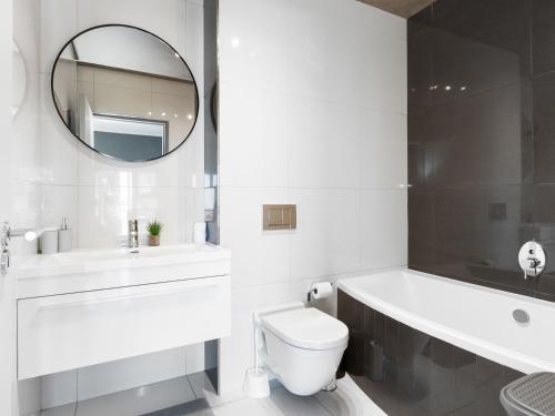 a bathroom with a toilet and a sink and a mirror at Upper East Side 407 in Cape Town