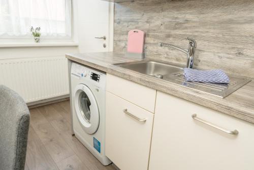 a kitchen with a sink and a washing machine at Easyapartments Leo in Linz