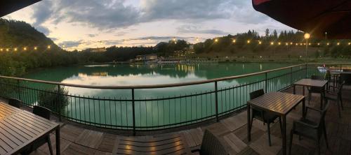a large lake with tables and chairs on a balcony at Hotel Al Lago in Lavarone
