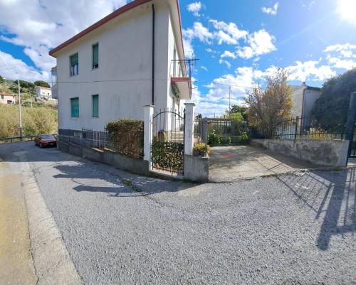 uma casa branca com uma cerca ao lado de uma rua em B & B di Massimo C em Spotorno