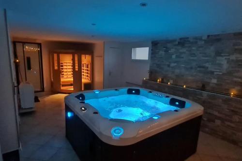 un ampio bagno con vasca idromassaggio con illuminazione blu di Villa Katharos avec SPA et piscine a Vesly