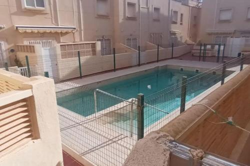 a swimming pool with a fence around it at adosado con piscina en Cabo de Gata 4p in El Cabo de Gata