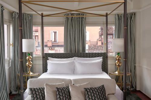 um quarto com uma cama grande e uma janela grande em Violino d'Oro Venezia em Veneza