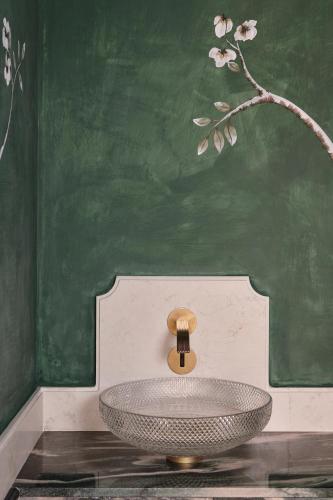 a bathroom with a sink in front of a green wall at Violino d'Oro Venezia in Venice