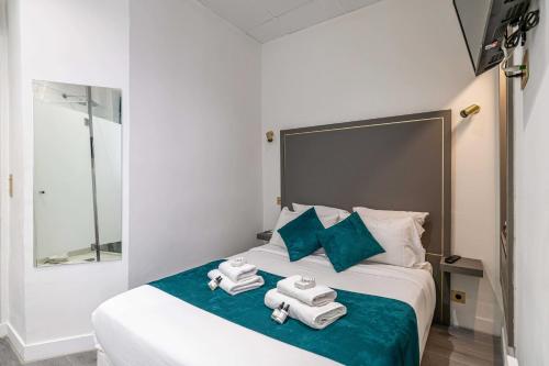 une chambre d'hôtel avec un lit et des serviettes. dans l'établissement Hotel Avaton - 1 min du Palais - Cannes Centre, à Cannes