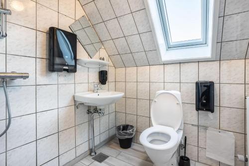 a bathroom with a toilet and a tv on the wall at B&B by the Sea Hirtshals in Hirtshals