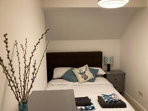 1 dormitorio con 1 cama con mesa y lámpara en Henley Town Rooms, en Henley on Thames