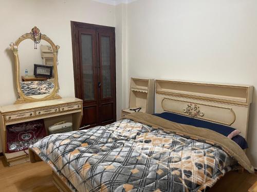una camera da letto con un letto con specchio e un comò di Elnoras city ismailia a Ismailia
