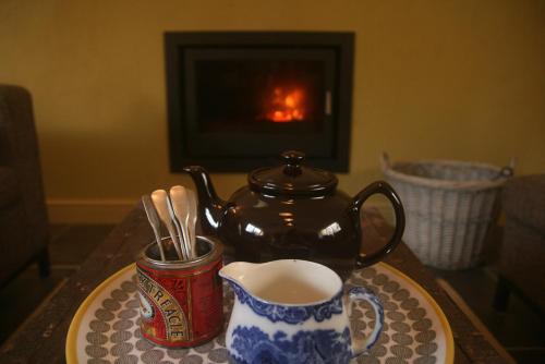 um bule de chá e uma chávena de café numa mesa em Creatively converted barn in accessible rural spot em Llanwrda