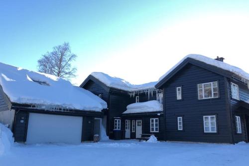 una casa negra con nieve en el techo en Sjarmerende leilighet i Sirdal, en Haugen