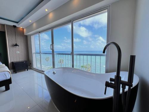 a bath tub in a bathroom with a view of the ocean at Villa Marbella by Potenza Rentals in Santo Domingo