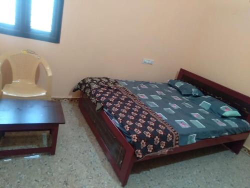 a bedroom with a bed and a table and a desk at Surukuttyyatra in Rāmeswaram